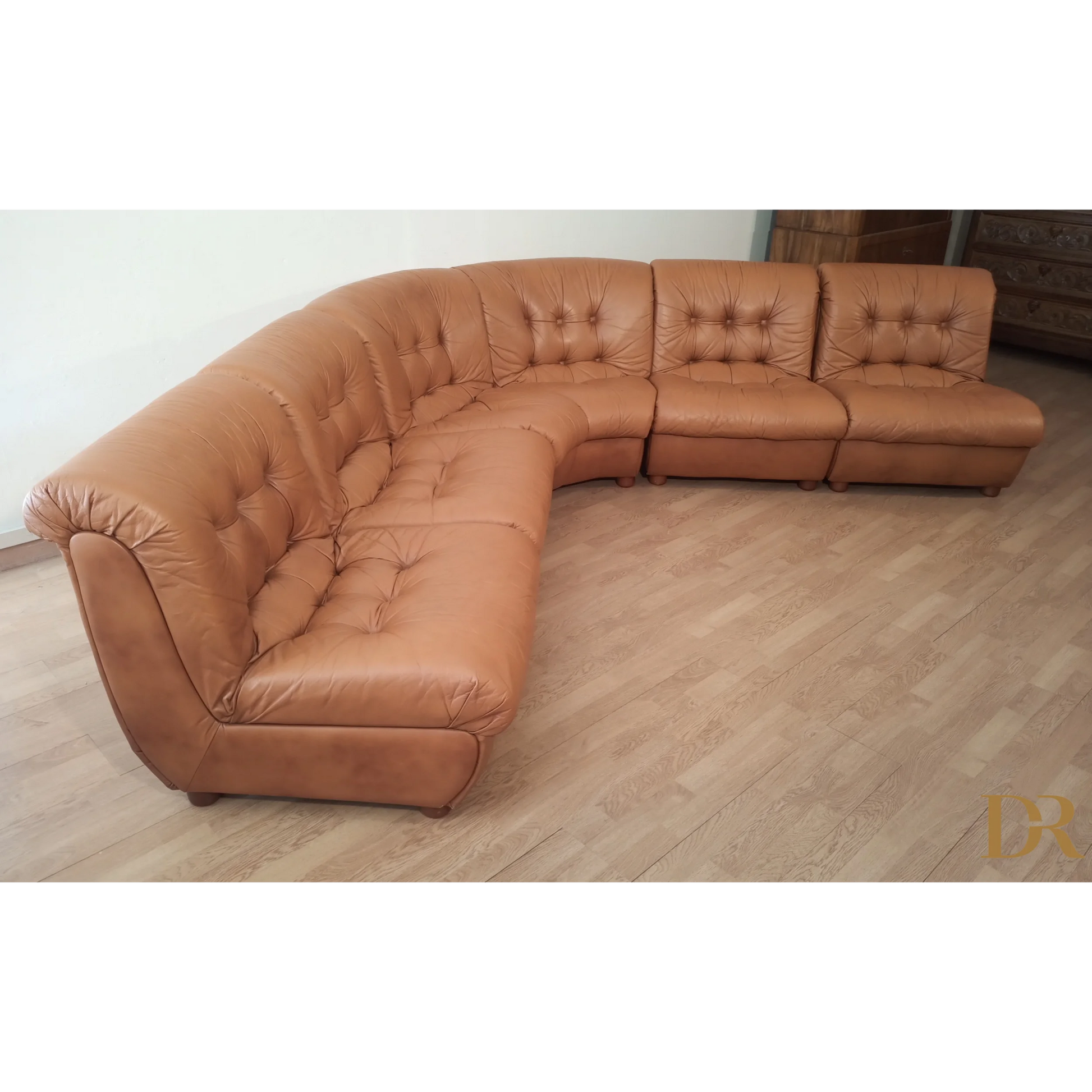 Divano modulare vintage in pelle cognac con cuscini tufted elegante e curvato