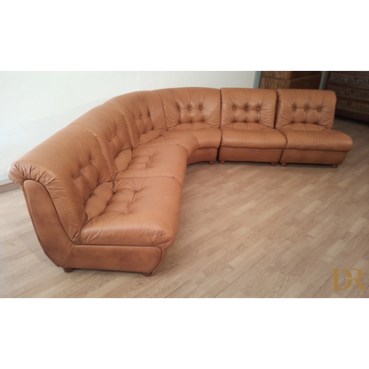 Divano modulare vintage in pelle cognac con cuscini tufted elegante e curvato