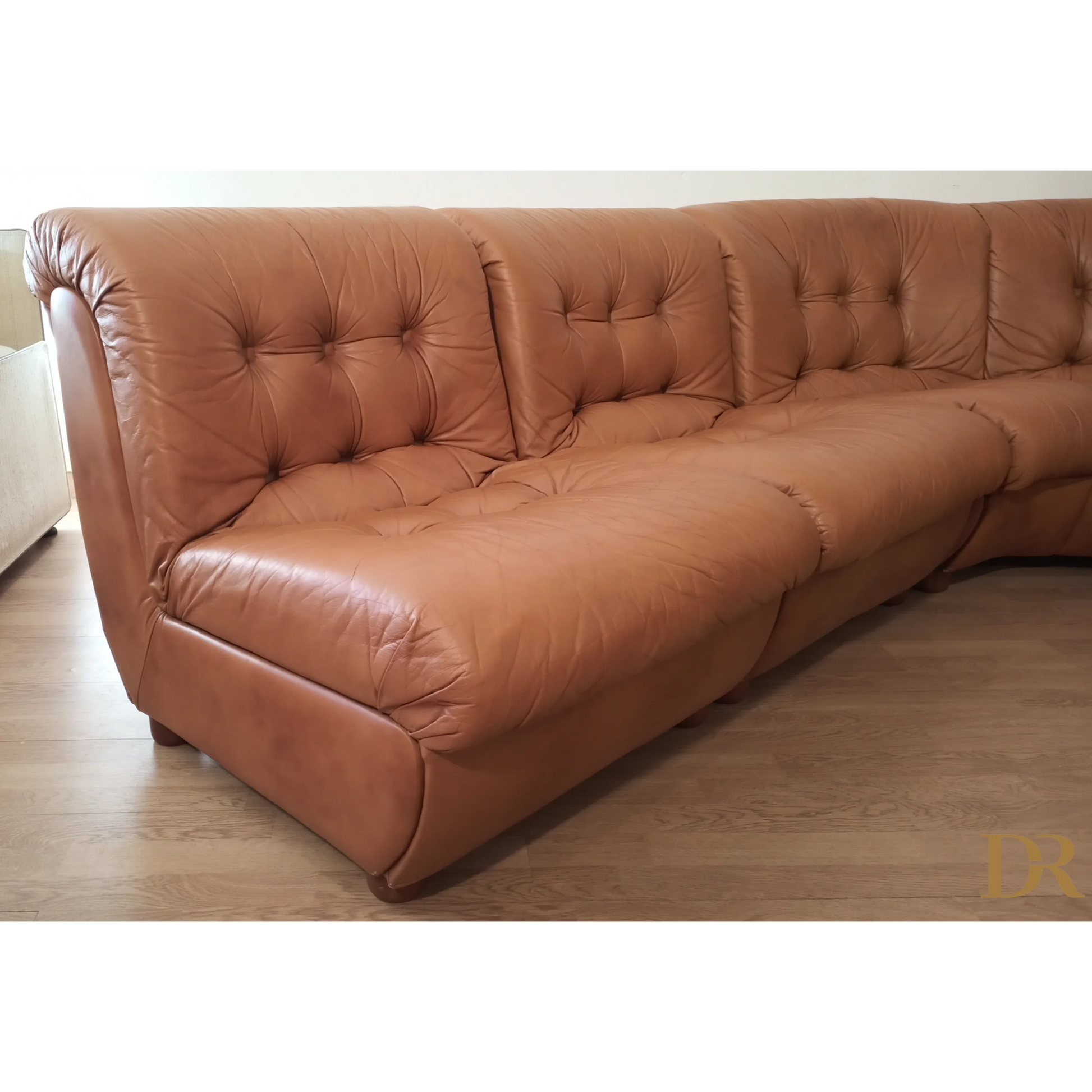 Divano modulare vintage in pelle cognac con design moderno e rivestimento tufted