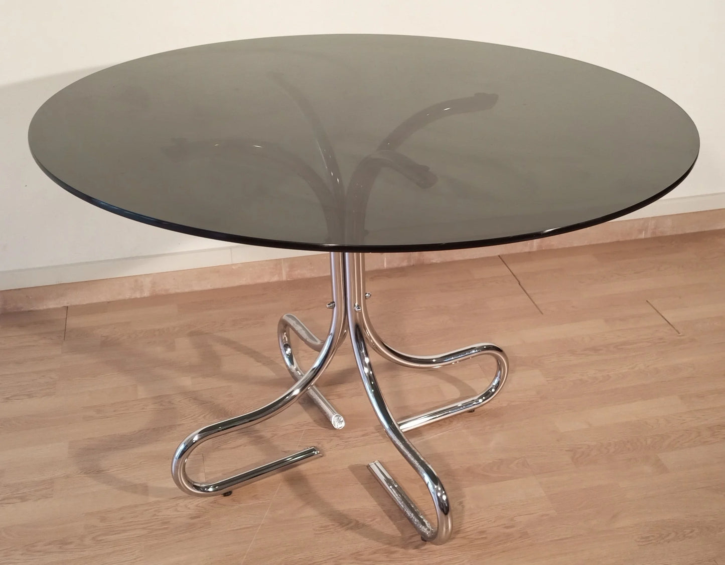 Tavolino da caffè con base curva in acciaio cromato e piano rotondo in vetro fumé design italiano